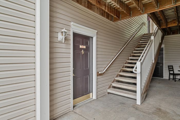 Inviting apartment entrance with private stairway and elegant lighting.