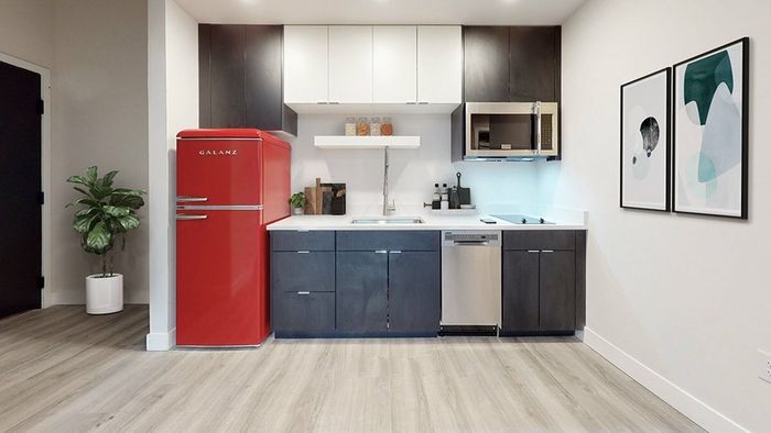 Space-saving kitchen in apartments near LoHi with two-tone cabinets, quartz counters, and convenient placement near the front door.