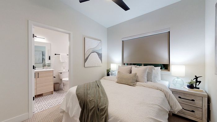 Bedroom with cozy decor and natural tones with attached bath