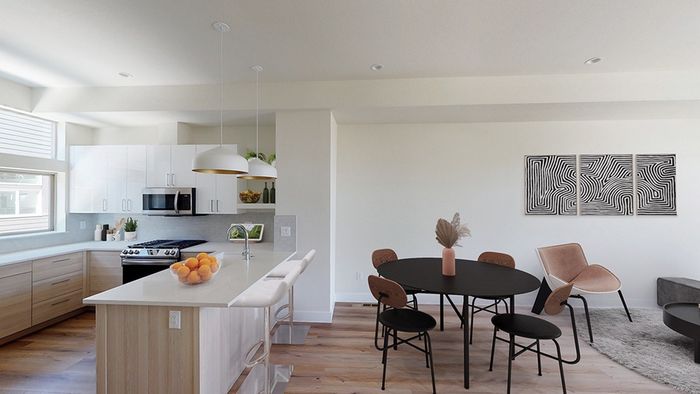 Modern kitchen with stainless steel appliances, gas cooking, open shelving for decor and barstools overlooking the dining area