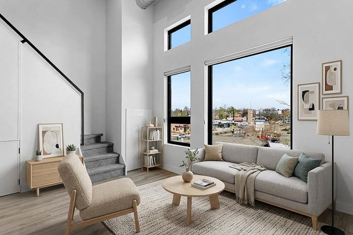 Bright and inviting living room with modern furniture, large windows offering city views, and stylish decor accents.