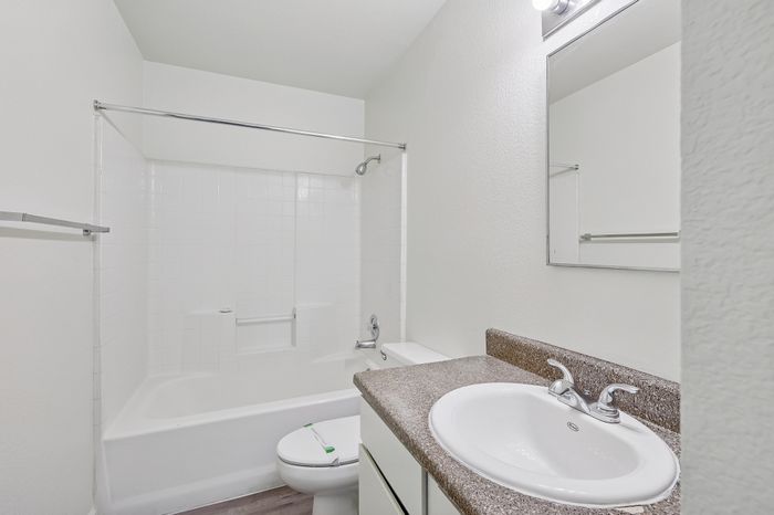 Bright and modern bathroom featuring a sleek white bathtub, elegant vanity, and contemporary fixtures.