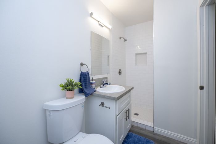 Modern bathroom with elegant white tile shower, sleek vanity, and fresh decor for a serene atmosphere.