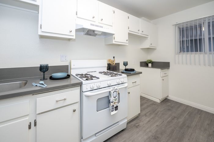 Modern kitchen with sleek white cabinets, stylish countertops, and a cozy feel. Perfect for culinary creativity.