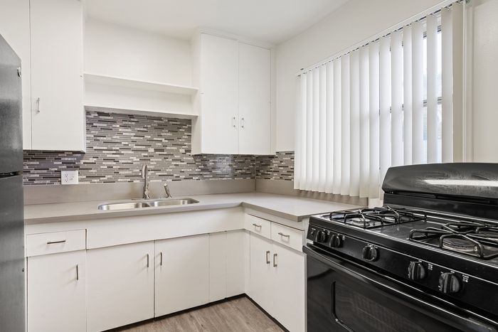 Modern kitchen with sleek cabinetry, stylish tile backsplash, and large window for ample natural light.