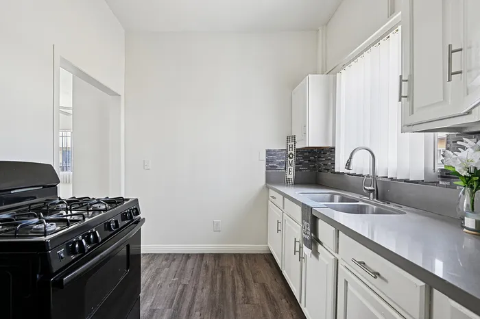Bright, modern kitchen featuring sleek countertops, elegant cabinetry, and a stylish backsplash, perfect for culinary enthusiasts.