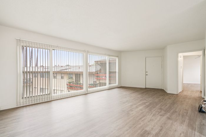 Bright and airy living room with large windows, wooden flooring, and modern design.