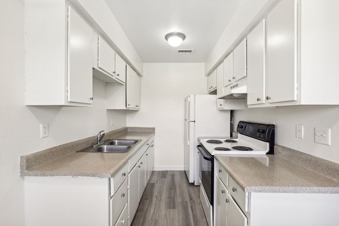 Bright, galley-style kitchen with modern white cabinets, sleek countertops, and a functional layout.