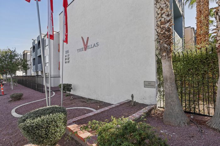 Modern, upscale apartment complex exterior with neatly manicured landscaping and red flags at The Villas.