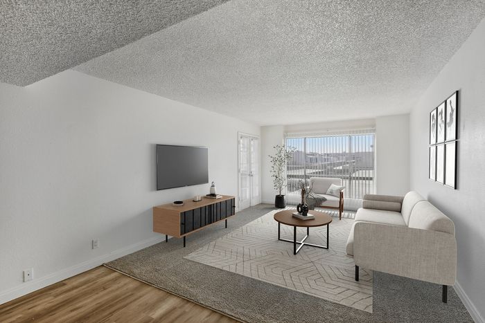 Bright and modern living room with cozy seating, elegant decor, and a panoramic view from large windows.