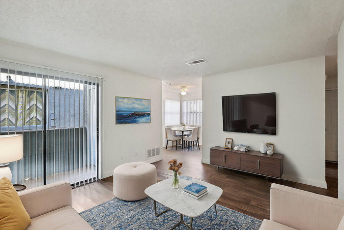 Chic modern living room with cozy seating and stylish dining area, boasting natural light and sleek decor.