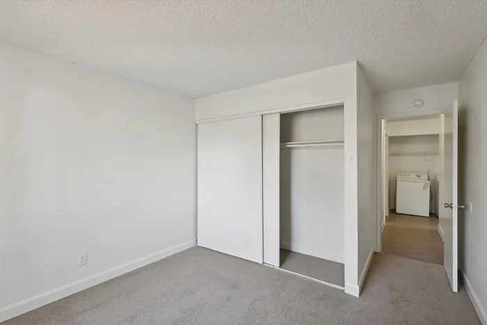 Bright and airy bedroom with modern closet space and convenient access to a laundry room.
