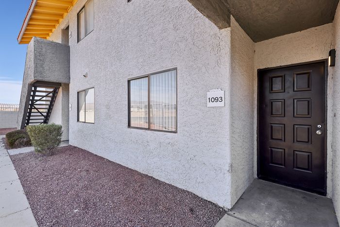 Charming apartment exterior with inviting entrance and modern stucco finish, featuring door number 1093.