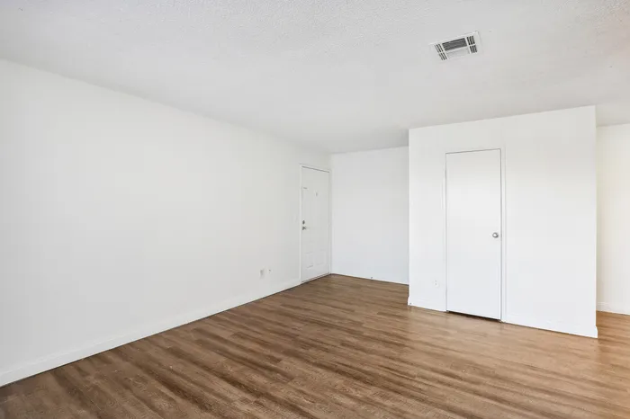 Bright, open space with modern wood flooring and fresh white walls, perfect for flexible living or office setup.