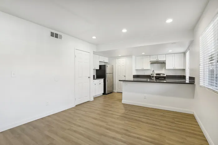 Sleek modern kitchen with stainless steel appliances, elegant white cabinetry, and polished countertops in an inviting open layout.
