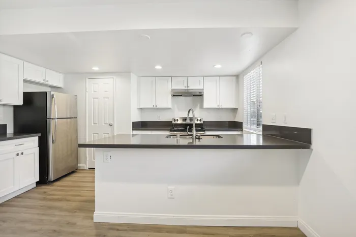 Modern kitchen with sleek stainless steel appliances and elegant white cabinetry, perfect for culinary enthusiasts.
