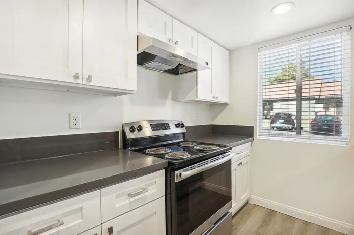 Bright modern kitchen with sleek countertops, stainless steel appliances, and ample white cabinetry offering a fresh and inviting space.