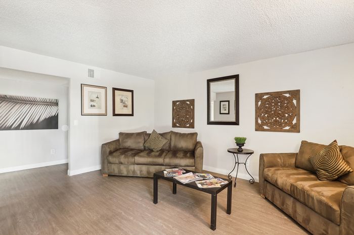 Inviting living room with cozy brown sofas, stylish decor, and natural light, offering a perfect blend of comfort and elegance.