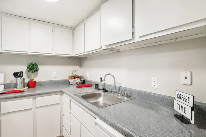 Bright and modern kitchen with sleek countertops, ample cabinetry, and inviting decor perfect for culinary enthusiasts.