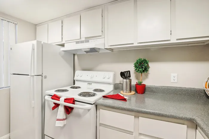 Charming kitchen with modern white cabinetry, sleek countertop, and cozy accents for a welcoming cooking space.