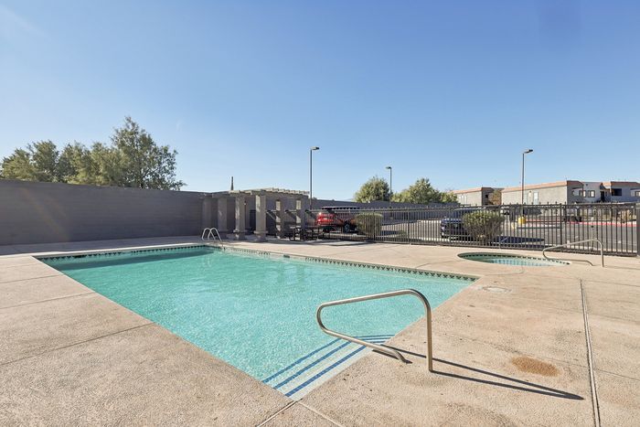 Inviting outdoor pool area with clear blue water, perfect for relaxation and leisure in a sunny setting.