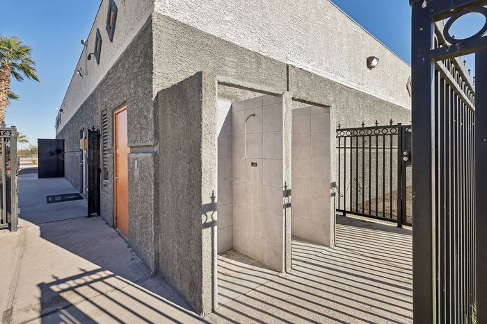 Modern outdoor shower area with sleek design and gated entry, perfect for a refreshing experience in sunny surroundings.