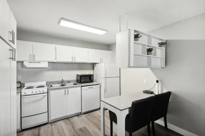Contemporary kitchen with sleek white cabinets, modern appliances, and cozy dining nook.