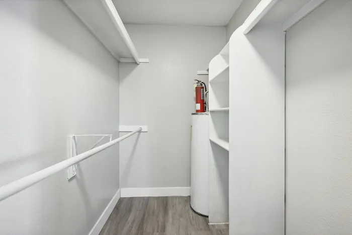 Bright and spacious storage area featuring sleek shelving and ample hanging space, perfect for organizing and maximizing functionality.