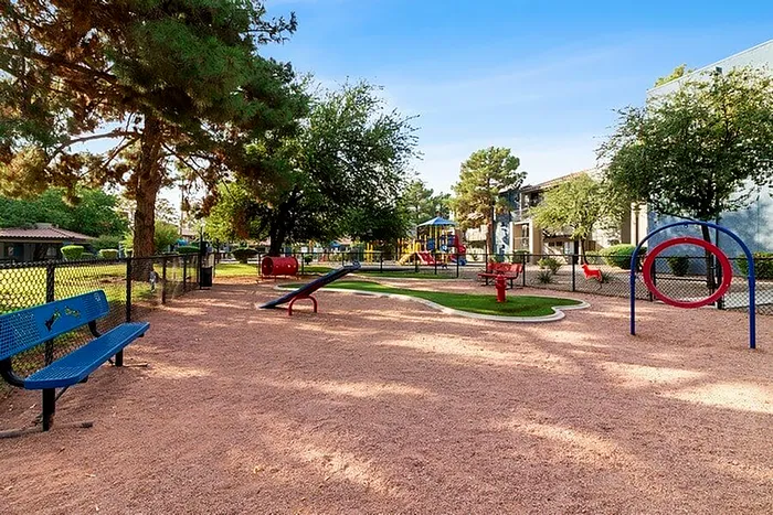 Charming community playground with vibrant slides, benches, and lush greenery, perfect for family enjoyment.