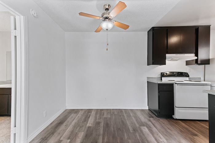 Contemporary apartment featuring a cozy kitchen with modern cabinetry, elegant flooring, and a stylish ceiling fan.