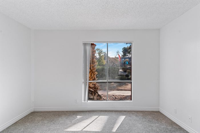 Bright and airy room with large window showcasing a scenic garden view, perfect for relaxation.