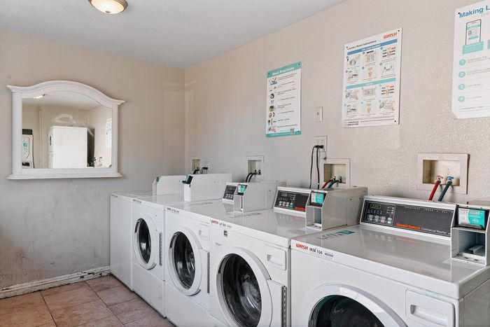 Bright and efficient laundry room equipped with multiple modern washing machines, promising convenience and ease.