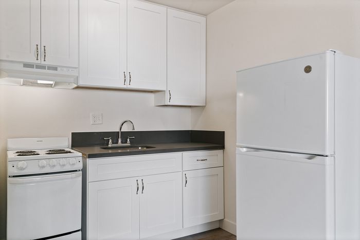 Modern kitchen with sleek white cabinets, spacious countertop, and essential appliances for a stylish culinary space.