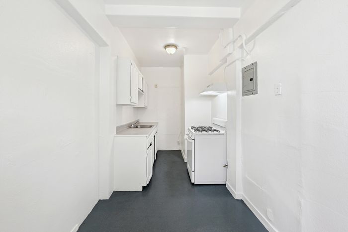 Charming and compact kitchen with bright white cabinetry and modern appliances.