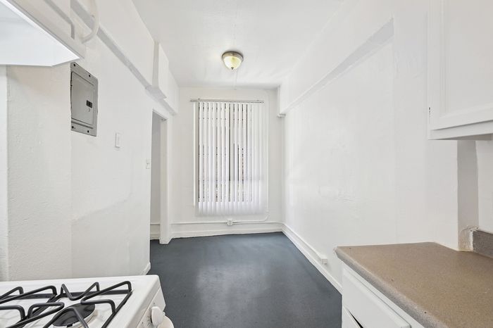 Bright, inviting kitchen with modern gas stove, ample natural light, and sleek countertops, ideal for culinary adventures.
