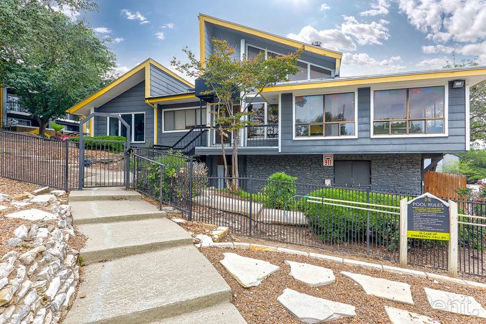 Stunning contemporary apartment building with bold architecture and spacious windows, surrounded by lush greenery and stylish landscaping.