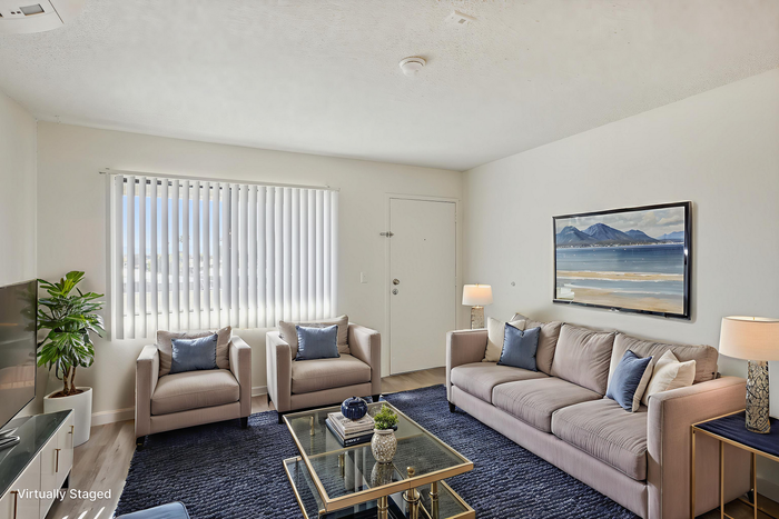 Bright and inviting living room with modern decor, plush seating, and a large window for ample natural light.