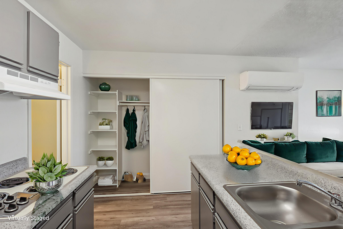 Contemporary kitchen with sleek countertops and vibrant decor, featuring a cozy open-plan living space in modern apartment.