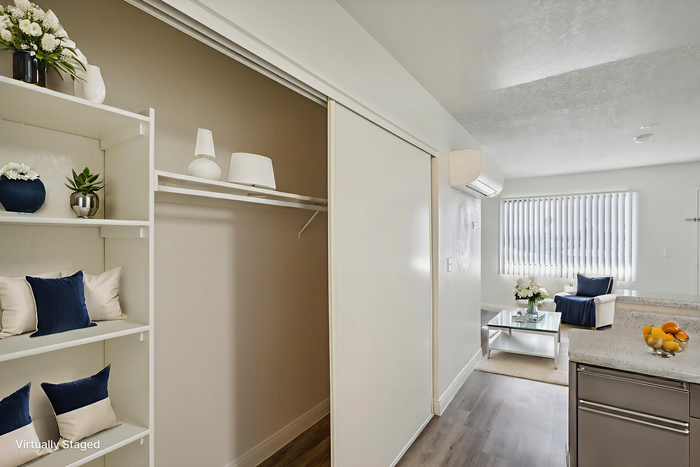 Chic and modern apartment interior showcasing a cozy living area with elegant decor, bright natural light, and a stylish kitchen countertop.