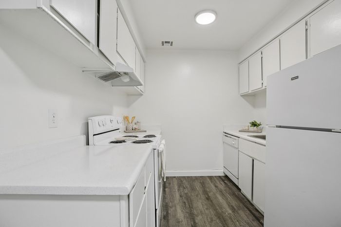 Modern kitchen with sleek white cabinetry, stylish countertops, and energy-efficient appliances, offering a bright and inviting space.