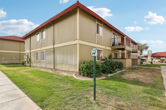 Charming apartment building with a welcoming facade, lush greenery, and pet-friendly amenities, offering relaxed suburban living.