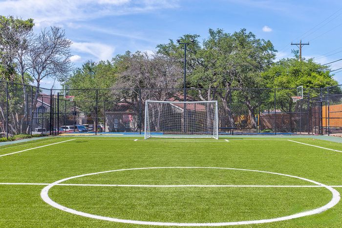 Inviting sports complex featuring a pristine soccer field with vibrant green turf and surrounding trees, perfect for outdoor activities.