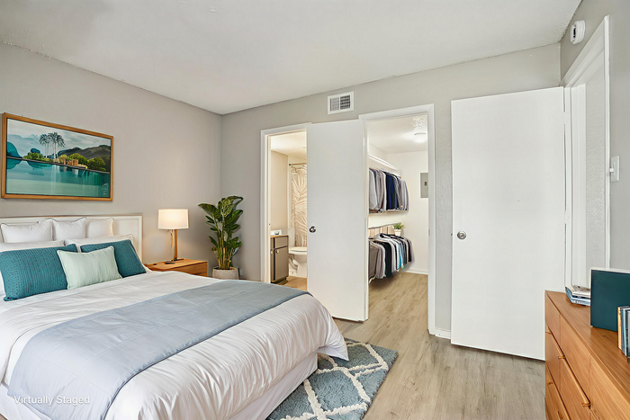 Elegant bedroom with modern decor, featuring a cozy bed, stylish artwork, and a spacious walk-in closet.