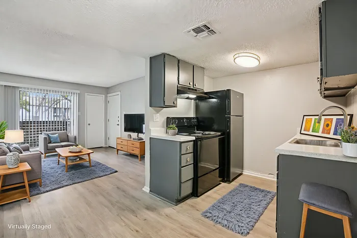 Chic and cozy open-plan apartment featuring a stylish kitchen with modern appliances, a comfortable living area with elegant furnishings, and floor-to-ceiling windows offering abundant natural light.