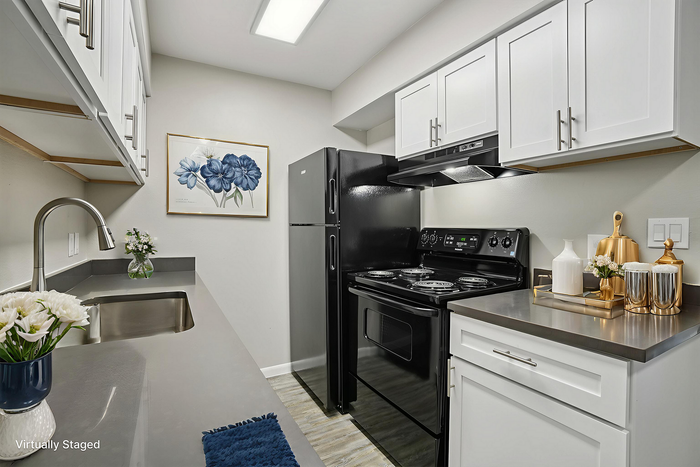 Chic, virtually staged kitchen featuring modern white cabinetry, sleek black appliances, and elegant decor.