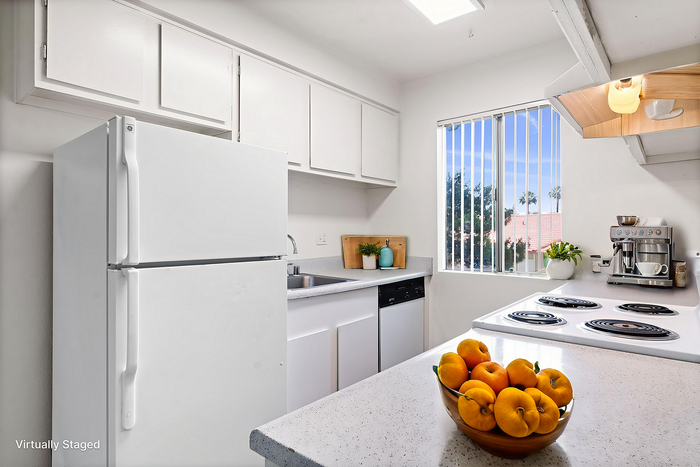 Bright and airy kitchen with modern white cabinetry, quality appliances, and a scenic window view with natural lighting.