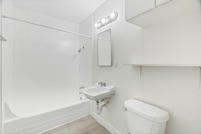 Bright, modern bathroom featuring a clean white design with a bathtub, sleek sink, and ample storage space.