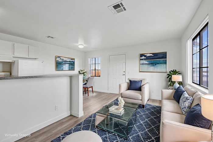 Bright and modern living area with cozy seating, stylish decor, and large windows for natural light. Open concept includes a chic dining space, perfect for contemporary living.