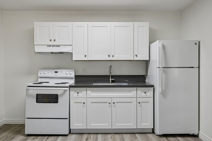 Sleek kitchen design featuring modern white cabinetry, a spacious refrigerator, and an electric stove, enhancing functionality and style.
