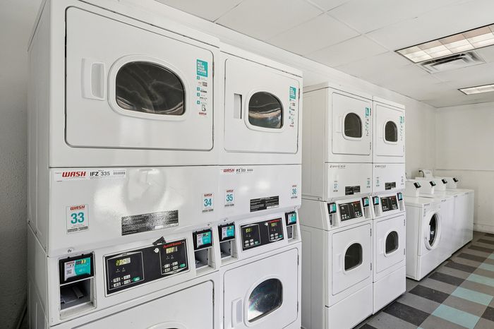 Modern apartment laundry room equipped with state-of-the-art stacked washers and dryers, offering convenience and efficiency.